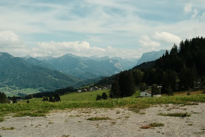 Dorf mit Bergpanorama auf einer Alpenwiese